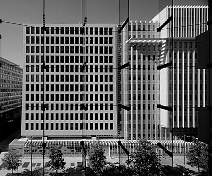 Office building photographed from glass-enclosed portico across the street